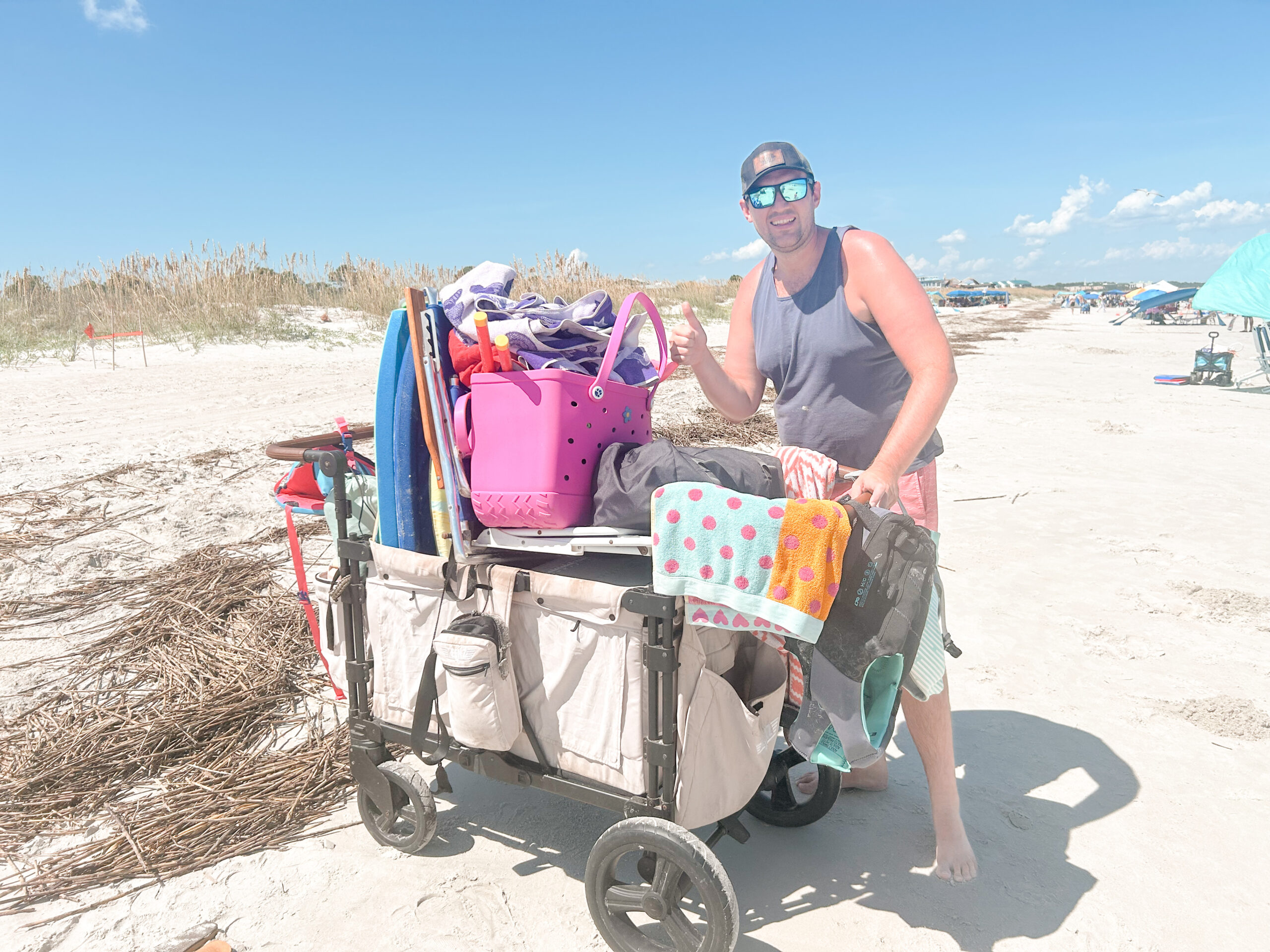 Man standing next to all beach gear packed in a wagon.